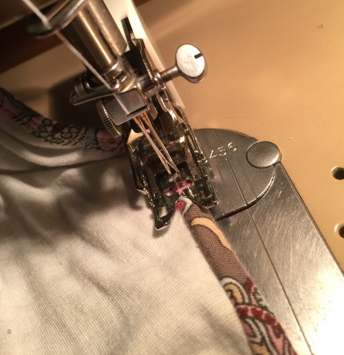 Wrap binding around to back and topstitch.